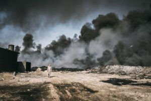 Man walking in front of huge black smoke cloud