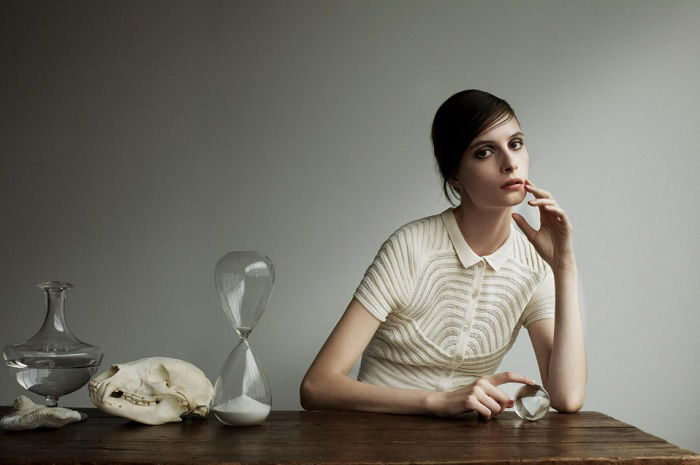 Woman at a table next to an hourglass