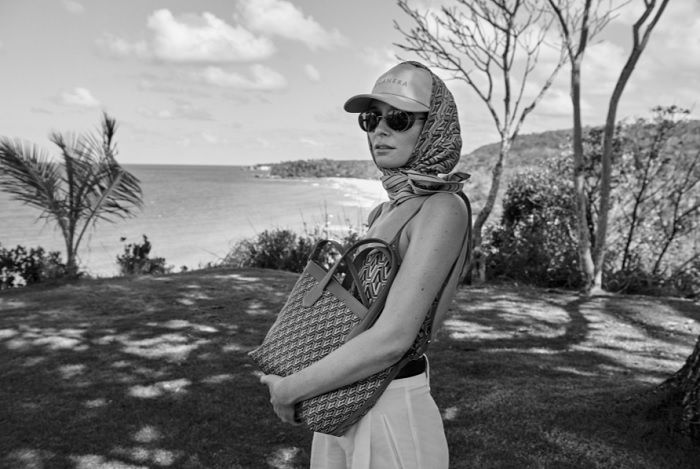 woman in a cap and scarf holding a bag