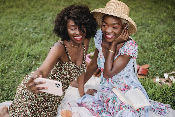 two ladies taking a selfie on a phone 