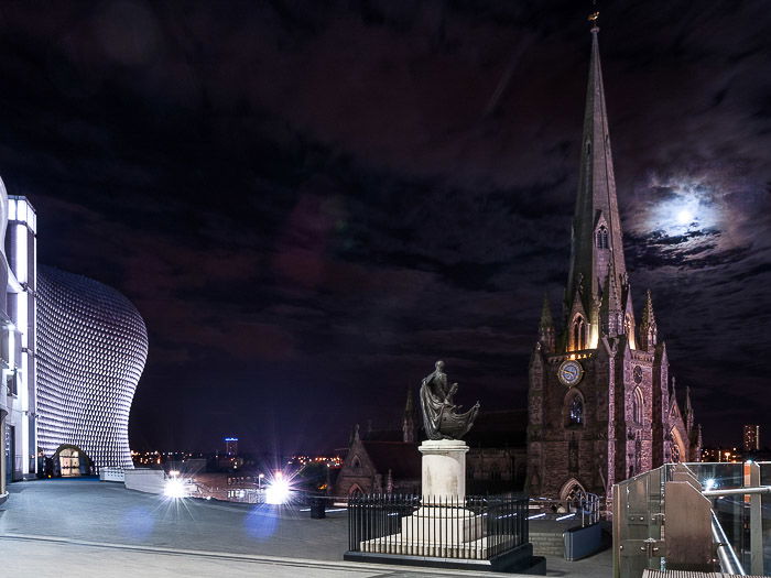 A picture of moon in the cloudy night sky over St Martin's Cathedral in Birmingham