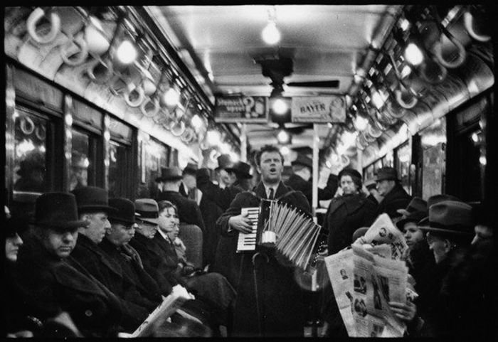 A black and white photo of a musician playing on a train by Walker Evans