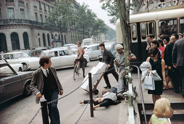 Busy street scene with delivery man and man lying on the street